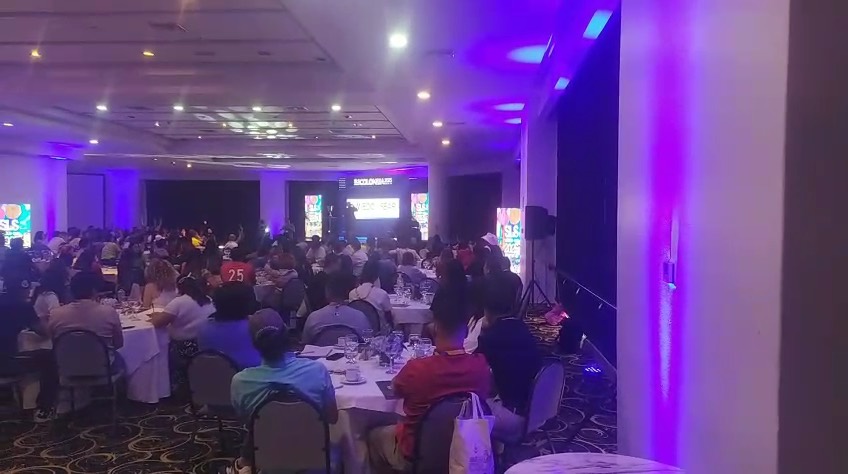 Salón de eventos lleno, vista desde el fondo